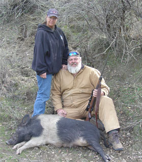 Husband and wife hunters with dutchbelt hog